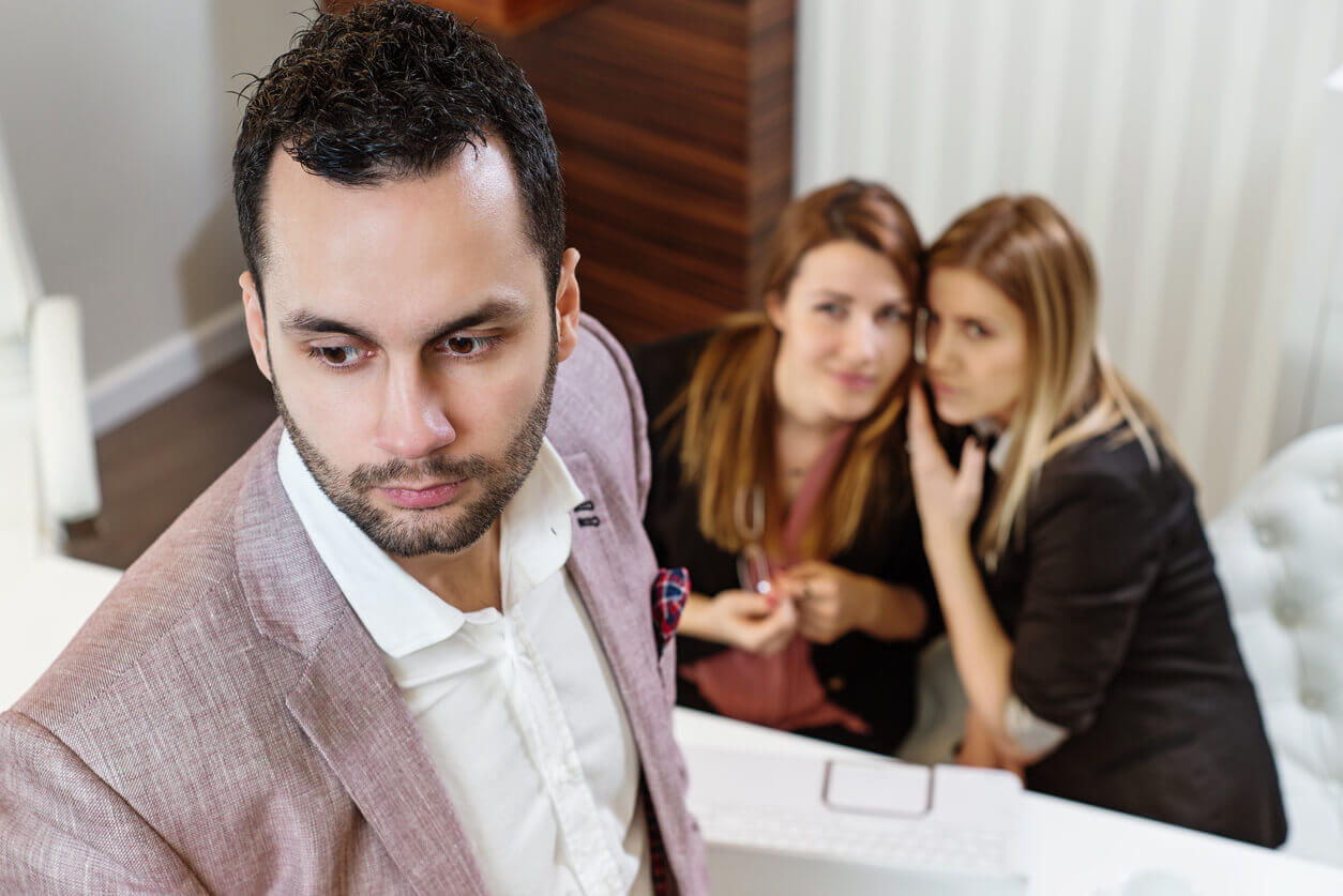 Women Gossiping About Ethnic Male Coworker