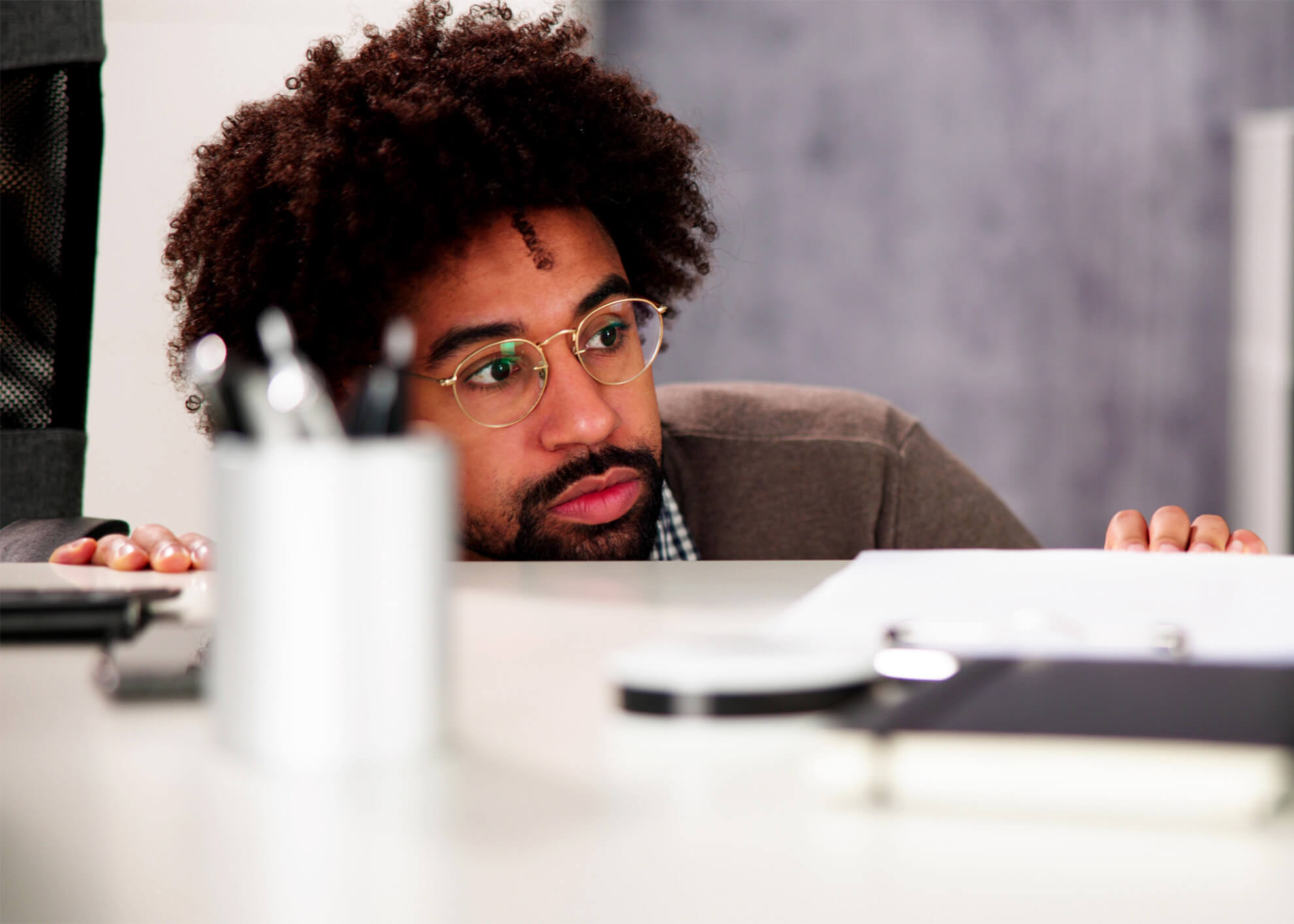 Male employee hiding behind desk during active shooter incident