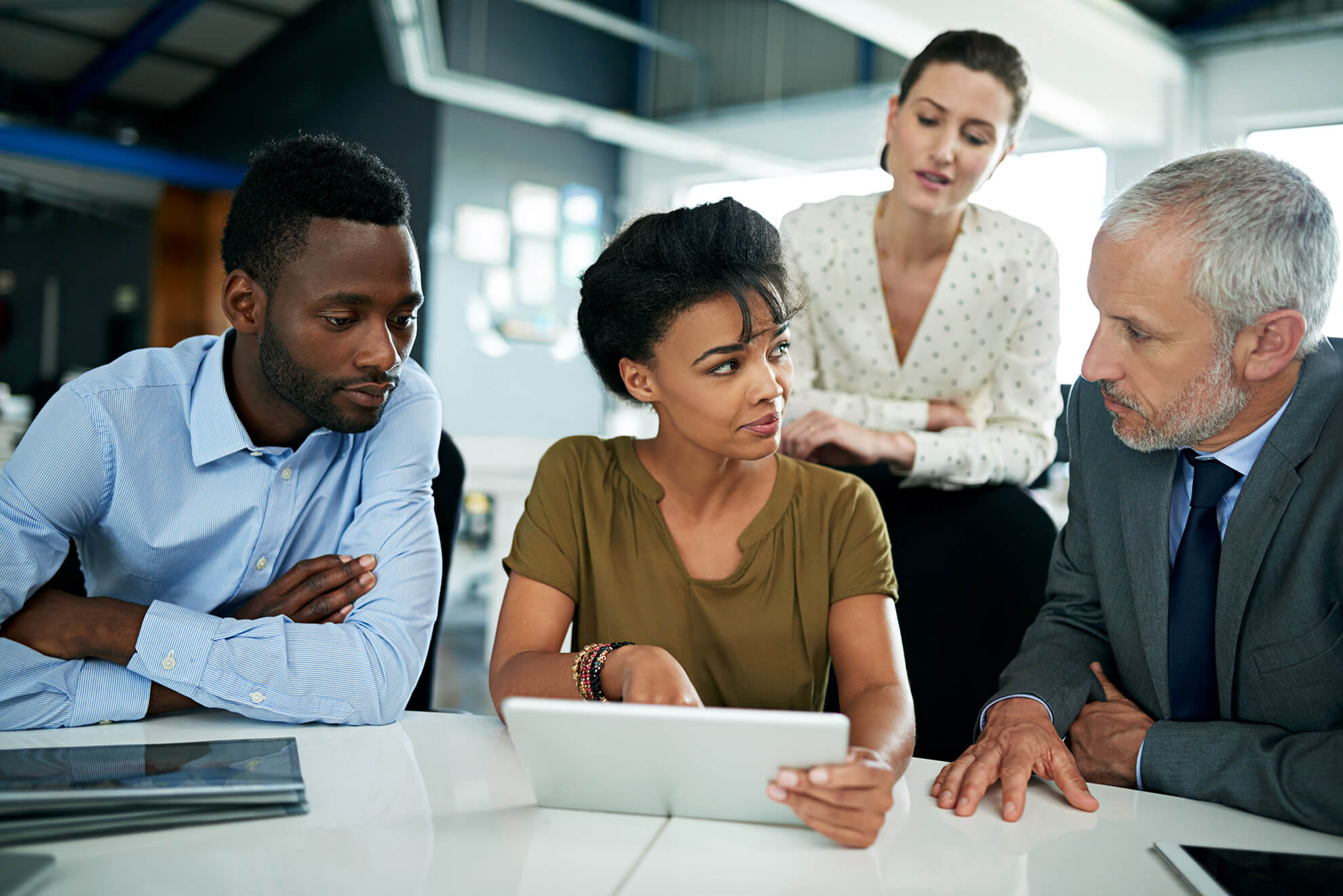 Female manager sitting and reviewing work policy on how to comply California SB 553 violence prevention with group of employees